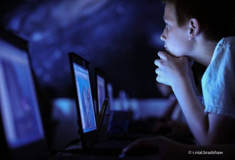 boy looking at computer in classroom