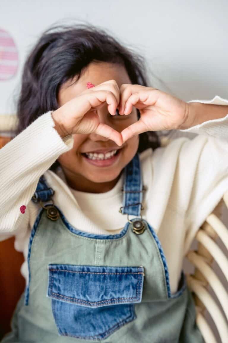 Young girl making a heart with her hands