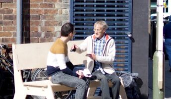 two people sitting on a bench in conversation