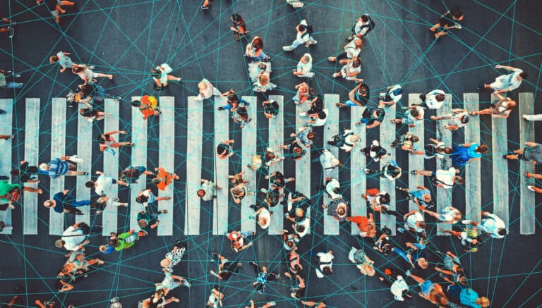 Aerial photograph of busy crosswalk, with technology lines connecting everyone.
