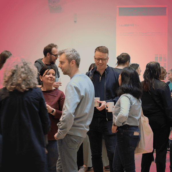 Edinburgh Futures Institute staff mingling and talking, red tint over image.