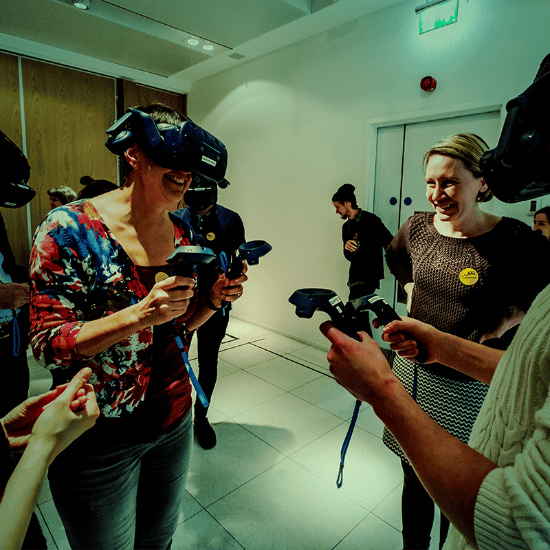 Group of people using VR headsets, green tint over image.