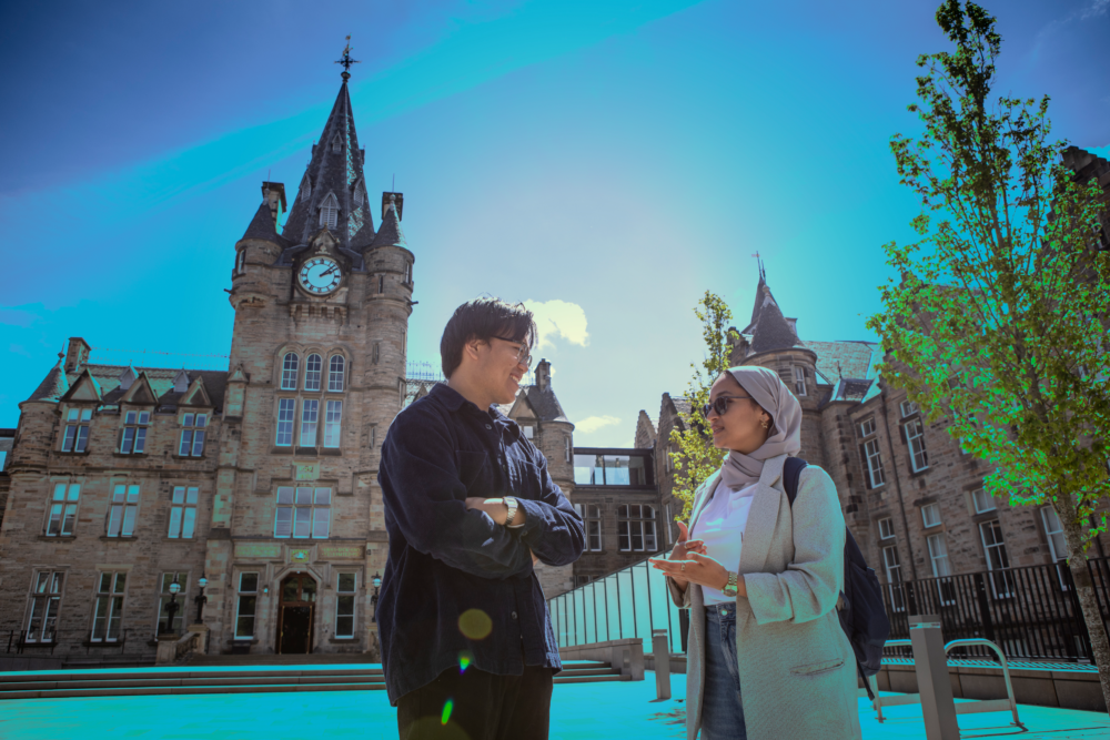 2 students standing outside historic edinburgh futures institute building