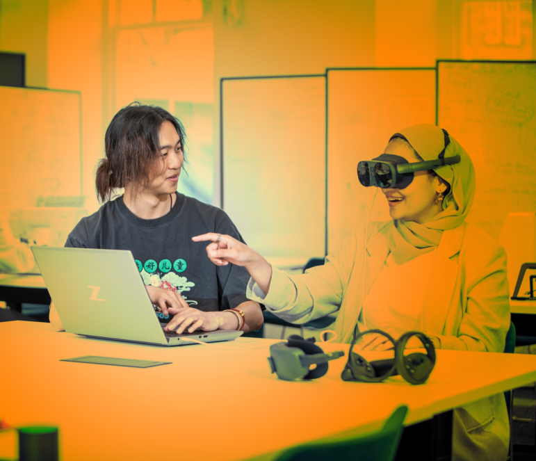 students in a classroom with a laptop and virtual reality headset