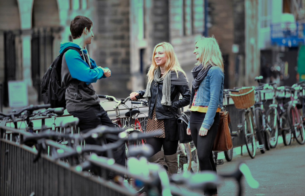 group of students talking standing next to bicycles