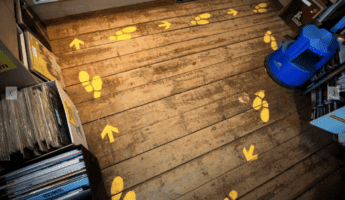 Yellow footsteps and arrows printed on wooden floor