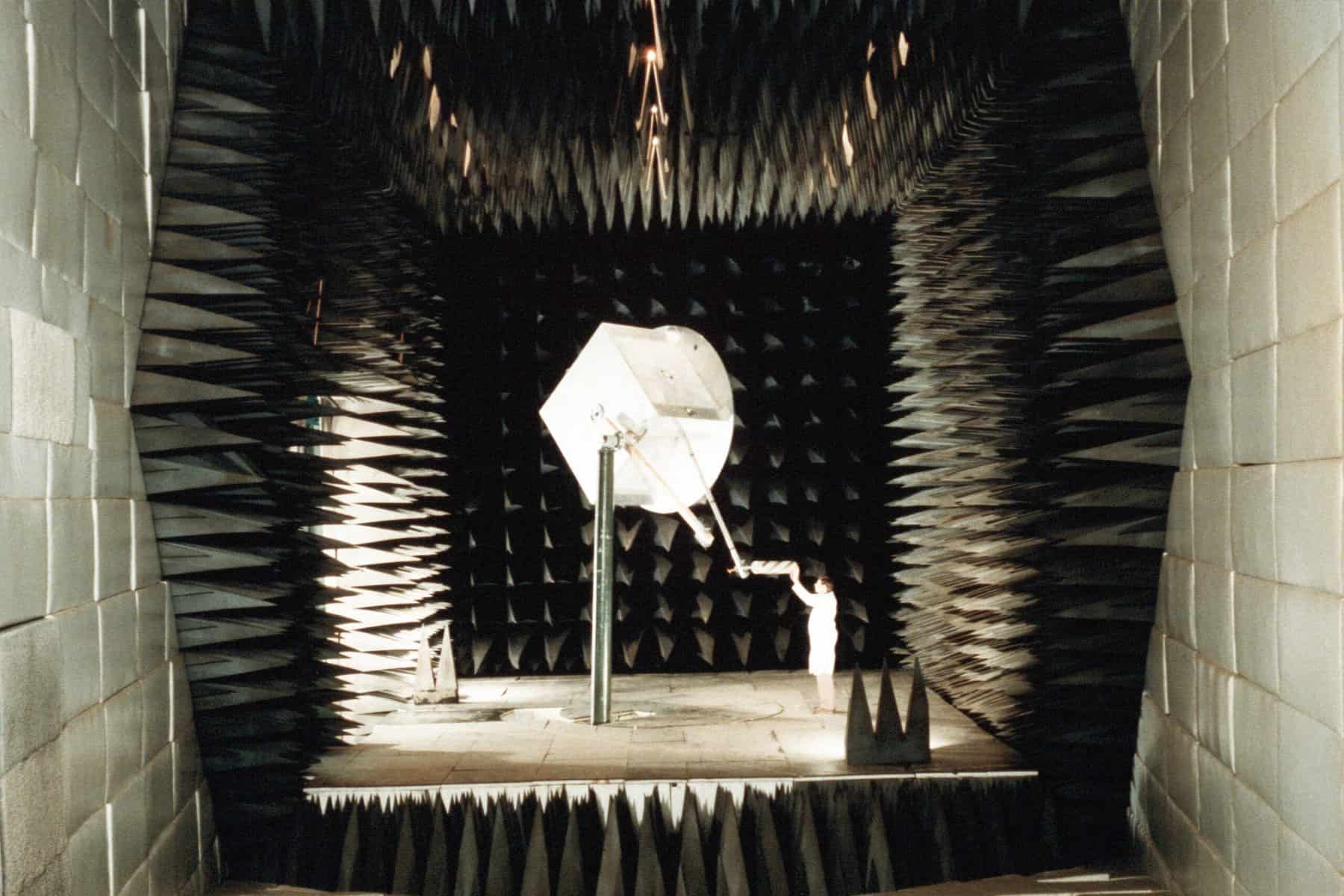Fred Domer makes an adjustment to the position of a unit before it is tested in an anechoic chamber in the Payload Checkout Facility at the Naval Research Laboratory (NRL).