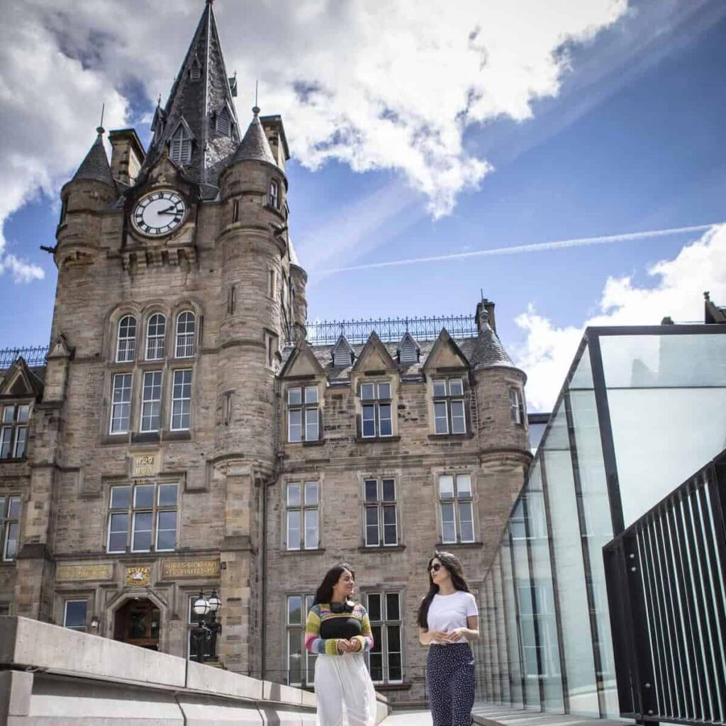 Two students walking outside the Edinburgh Futures Institute building