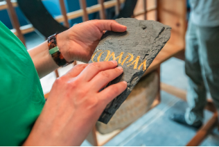 Person touching old roof slate