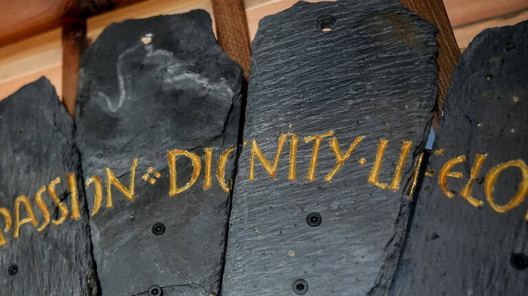 Slate from the Spirit Case sculpture displaying the words 'dignity'