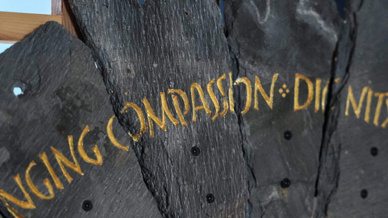 Slate from the Spirit Case sculpture displaying the words 'compassion'