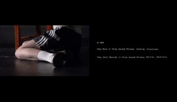 Georgia Gardner, Still from Body Memo (2023). The image shows a person in black shorts and white socks lying on the floor next to a stool. Text to the right reads: "67 BPM. They Move in Three Second Phrases. Glowing, Precarious. They [Are] Move(d) in Three Second Phrases. Partial, Uncertain.