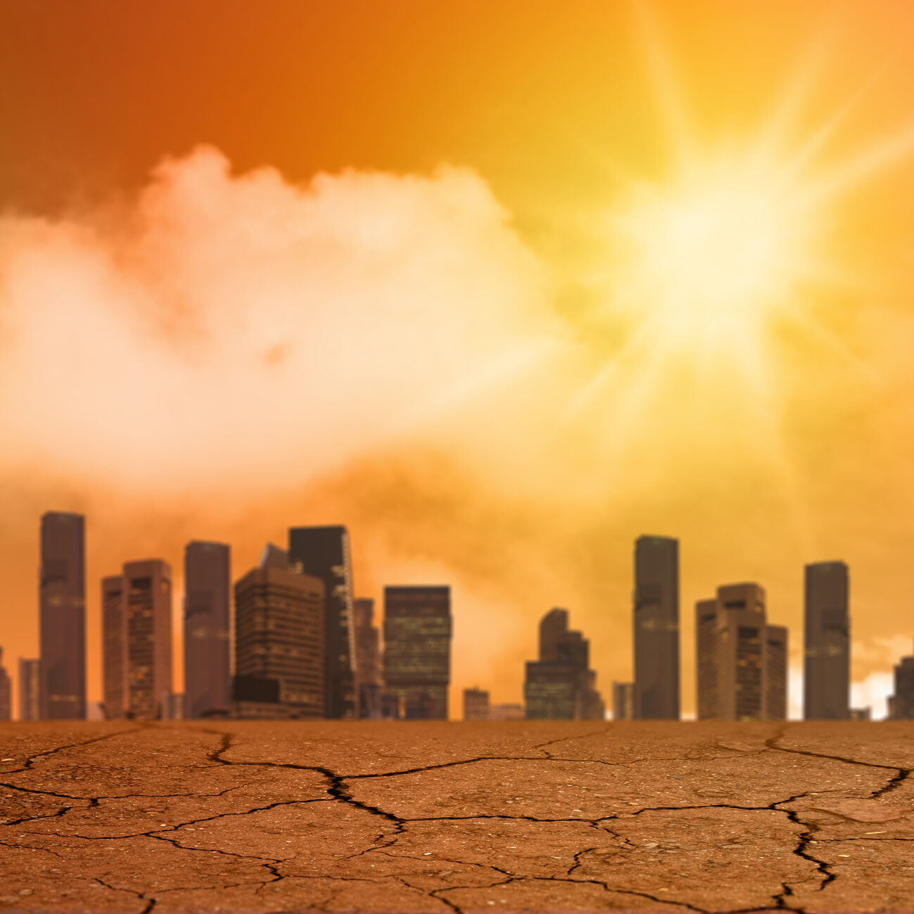 A city skyline under an intense, orange sun with cracked, dry ground in the foreground, suggesting extreme heat or drought conditions.
