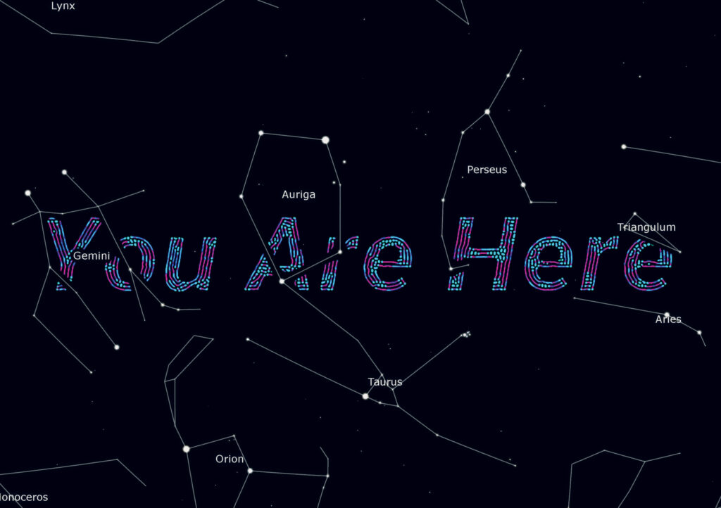 Digital illustration of constellations on a dark starry background with the words "You Are Here" in large multicolored text appearing among the constellation lines and names, such as Gemini, Auriga, Taurus, and Aries.