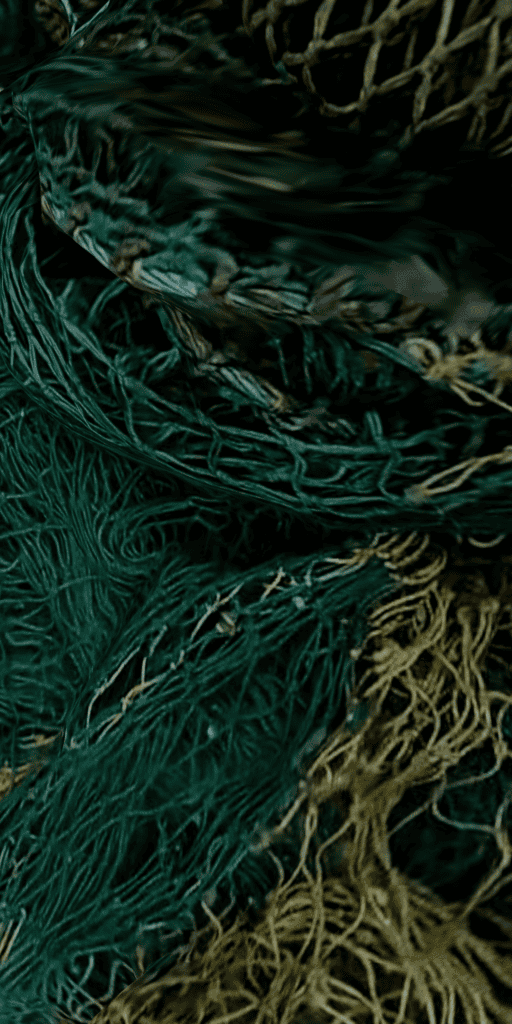 Close-up of tangled green and yellow fishing nets, showing detailed textures and overlapping mesh patterns.